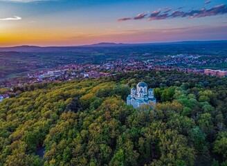 Aerial shot of St George Church in the middle of a forest in Oplenac, Topola, Serbia