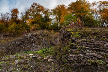 Nature in the autumn forest. High mountains under a blue cloudy sky. Nature in the autumn forest. Beautiful mountain landscape in autumn under a blue sky. Autumn view of the mountains.