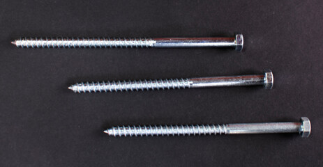 metal bolt isolated on black background. Chromed screw bolt. Steel bolt isolated. Nuts and bolts. Tools for work.