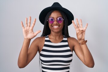 Young african american with braids wearing hat and sunglasses showing and pointing up with fingers number nine while smiling confident and happy.