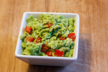Bowl of guacamole on a wooden table