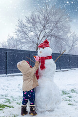 Children make a snowman in winter. Selective focus.