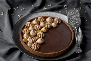 tarte au chocolat et caramel sur une nappe noire