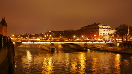 Fototapeta na wymiar Promenade au bord de la Seine, pendant une nuitée ou une soirée, éclairage avec des lampadaires jaunes, coin paisible et sombre, marche obscur