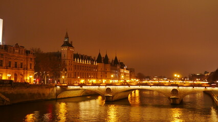 Fototapeta na wymiar Promenade au bord de la Seine, pendant une nuitée ou une soirée, éclairage avec des lampadaires jaunes, coin paisible et sombre, marche obscur