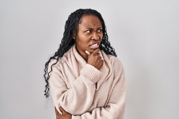 African woman standing over white background thinking worried about a question, concerned and nervous with hand on chin