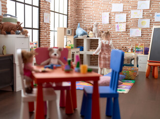 Adorable caucasian girl standing on back view at kindergarten