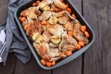 Roasted Rabbit Haunches in Pan with Stewed Vegetables on Rustic Wooden Table Surface
