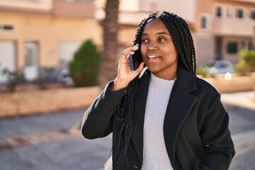 African american woman smiling confident talking on the smartphone at park