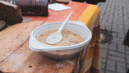 Social food, porridge in a disposable plastic plate, on the street in Ukraine