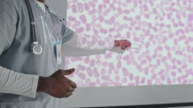 Medium section shot of unrecognizable African American medical worker making presentation at conference or giving lecture to students