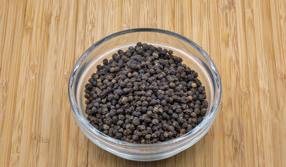 Black pepper closeup on wooden background
