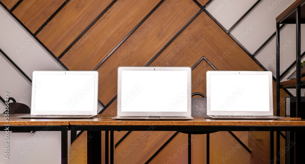 Poster Multiple laptop screen mockups on wood desk in modern office. Multi display, monitor mock up of computer displays
