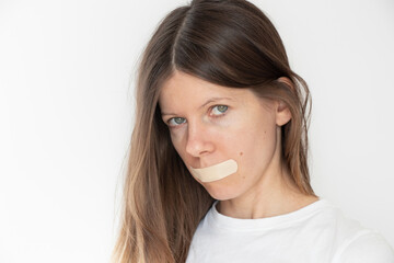 Girl with her mouth sealed with duct tape over isolated background ,be quiet and don't say anything