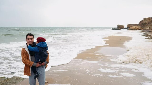 Lovely father and son kissing on the beach near the sea