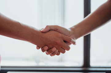 Two business women and male shaking hands.Shake hands and agree to do business together at outside the workplace..Bussiness and working concepts.