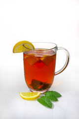 Glass cup of tea with lemon slices and mint leaves, isolated on white background