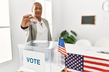 Senior african american woman holding i voted badge voting at electoral college