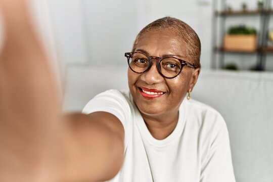 Senior african american woman make selfie by the camera sitting on sofa at home