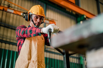 Factory workers or technician control lathe machine in factory.Asian worker man working in safety...