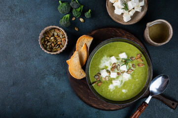 Broccoli cream soup in a bowl with toasted bread and cheese