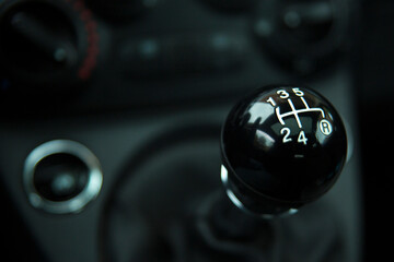 Closeup of manual transmission gear  of a city car. Black interior with chrome details.