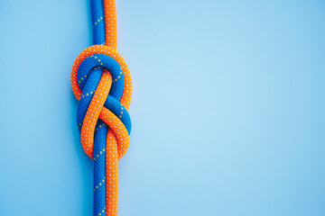 Eight knot on a rope on a blue background close up