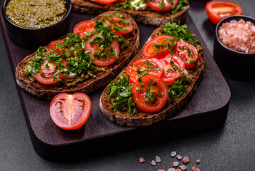 Tasty bruschetta with tomatoes, mozzarella, basil, spices and herbs