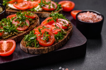 Tasty bruschetta with tomatoes, mozzarella, basil, spices and herbs