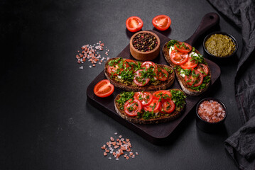 Tasty bruschetta with tomatoes, mozzarella, basil, spices and herbs