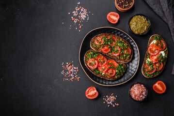 Tasty bruschetta with tomatoes, mozzarella, basil, spices and herbs