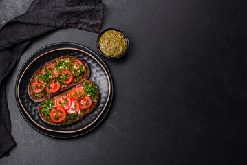 Tasty bruschetta with tomatoes, mozzarella, basil, spices and herbs