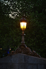 Vintage lighted street lamp on a wall early in the morning