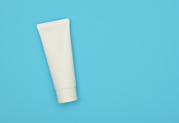 White tube of cream or toothpaste on blue