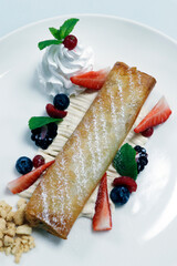 traditional apple strudel with whiped cream and fresh mix berries