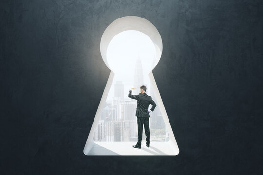 Abstract image of businessman standing in keyhole opening and looking into the distance on blurry city background. Vision, future and think concept.