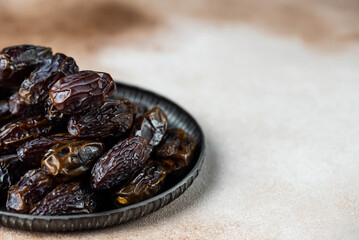 Dates fruit on oriental plate on white background. Dried organic Superfood.