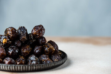 Dates fruit on oriental plate on white background. Dried organic Superfood.