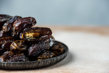 Dates fruit on oriental plate on white background. Dried organic Superfood.