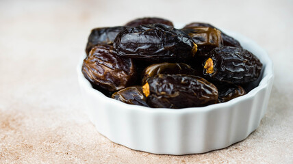 Dates fruit in bowl on white background. Dried organic Superfood.