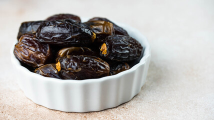 Dates fruit in bowl on white background. Dried organic Superfood.