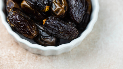 Dates fruit in bowl on white background. Dried organic Superfood.