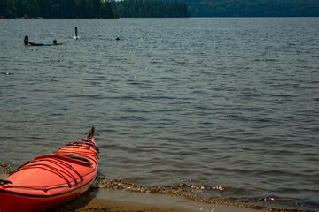 Red canoe on the shore of lake Dwight, Muskoka, Ontario, Canada