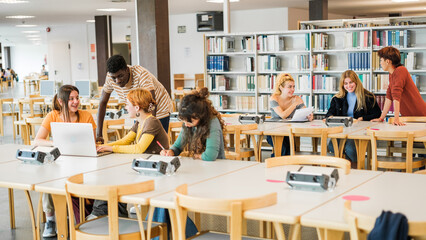 Fototapeta na wymiar Group of students studying in the university library together and sharing moments