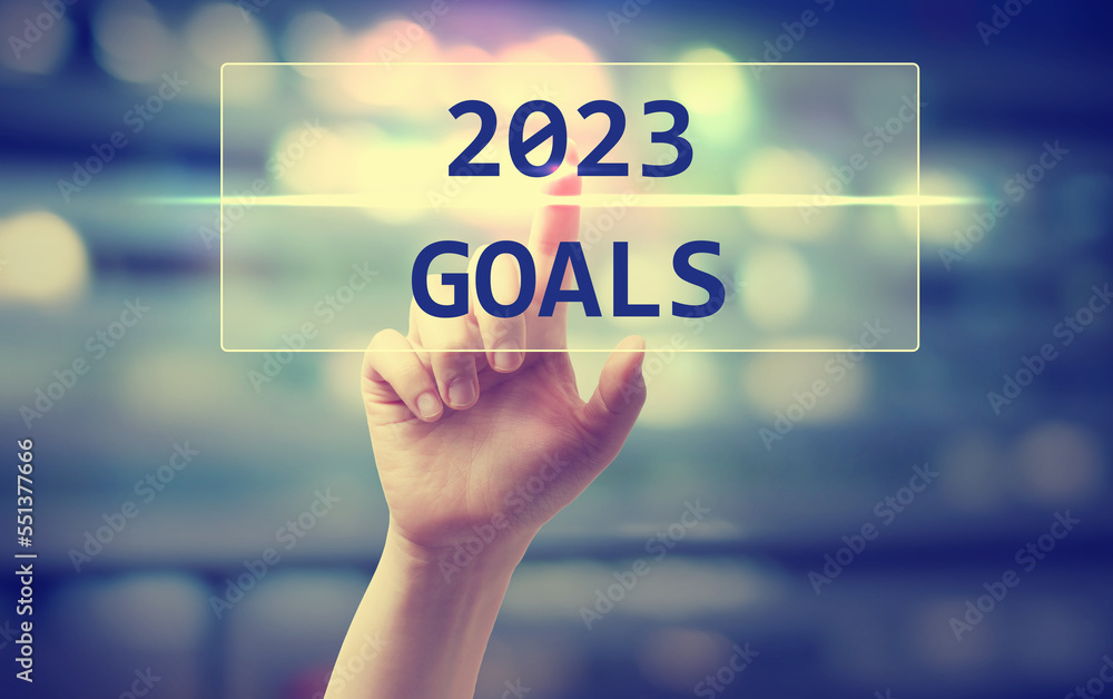 Poster 2023 goals concept with hand pressing a button on blurred abstract background
