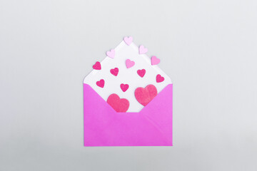 Pink envelope and hearts on a grey background. The concept of Valentine's day, love, dating and...