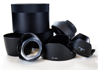 assorted sizes of professional camera lens hoods with white background