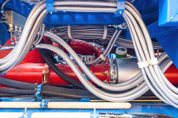 Pipes and metal hoses close-up. Industrial equipment. Flexible hoses in metal sheath. Fragment of...