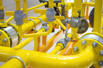 Yellow pipeline. Fragment of gas pipeline with flow control valves. Tangled pipes of different diameters. Pipes for gas transmission. Pipeline for supply of chemical products. Gas compressor unit