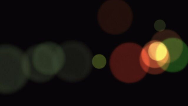Floating multi-colored circles with bokeh effect on a black transparent background with Alpha Channel. Abstract cosmic background. Background for promo and advertising. 4K video footage. 3D animation